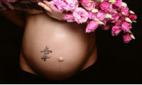 έγκυος γυναικα που κρατά λουλούδια κοντά στην κοιλιά της
