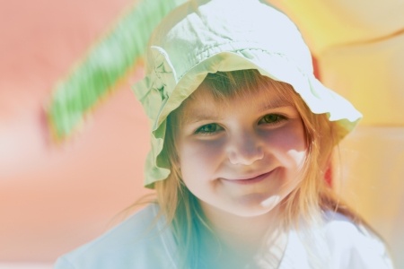 κοριτσάκι με άσπρο καπέλο χαμογελάει
